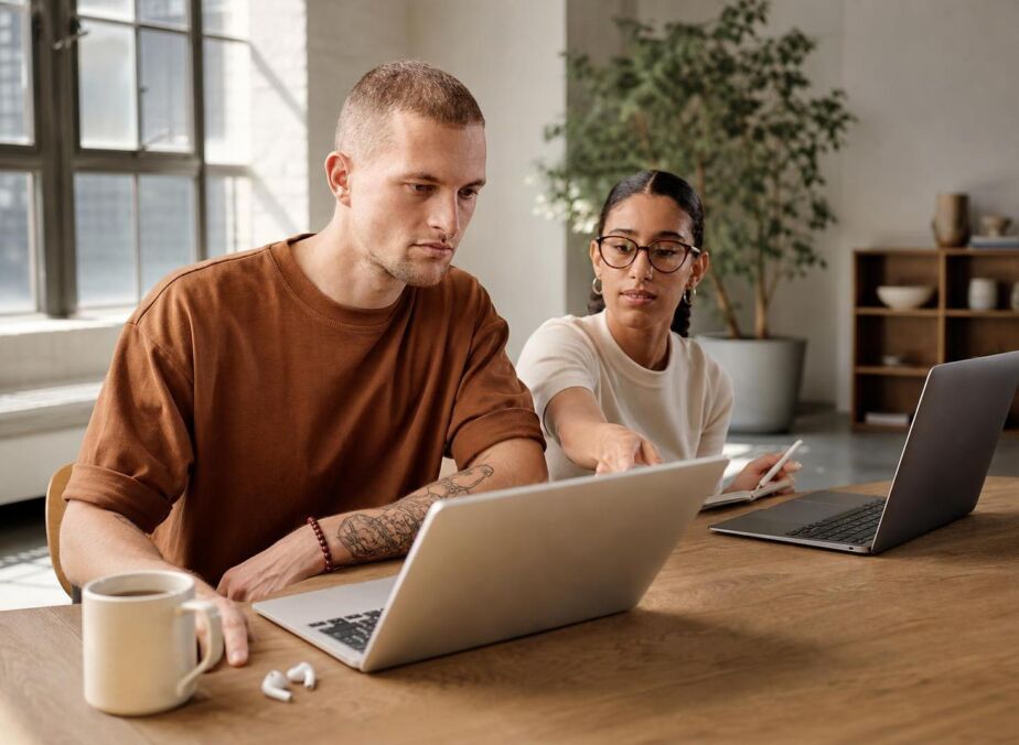 Two colleagues collaborating at laptops